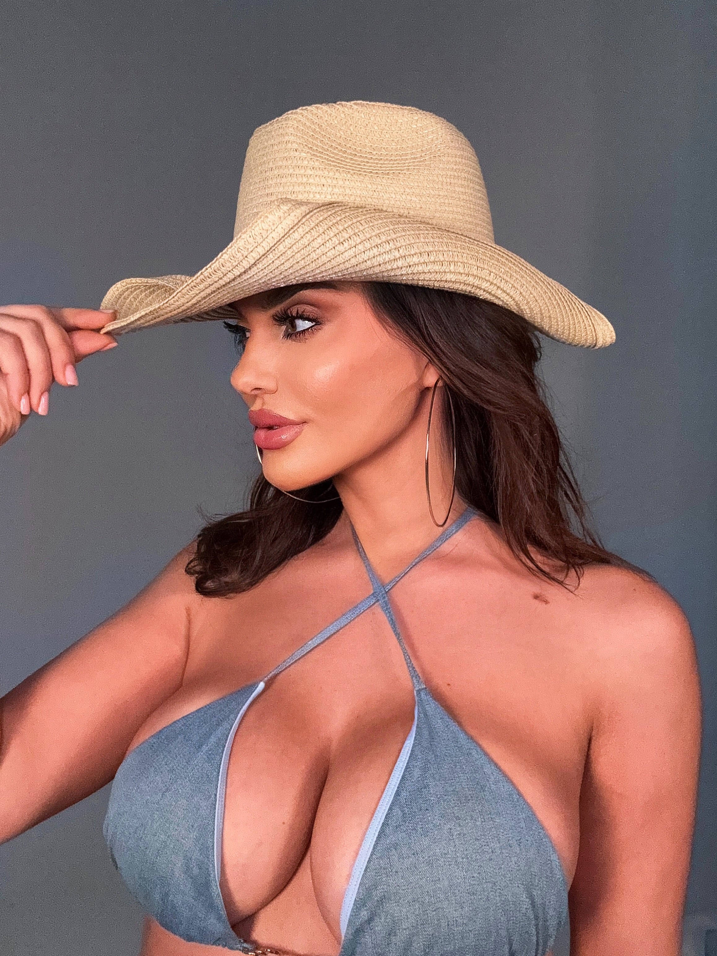 Woman wearing a cowgirl straw hat and blue bikini