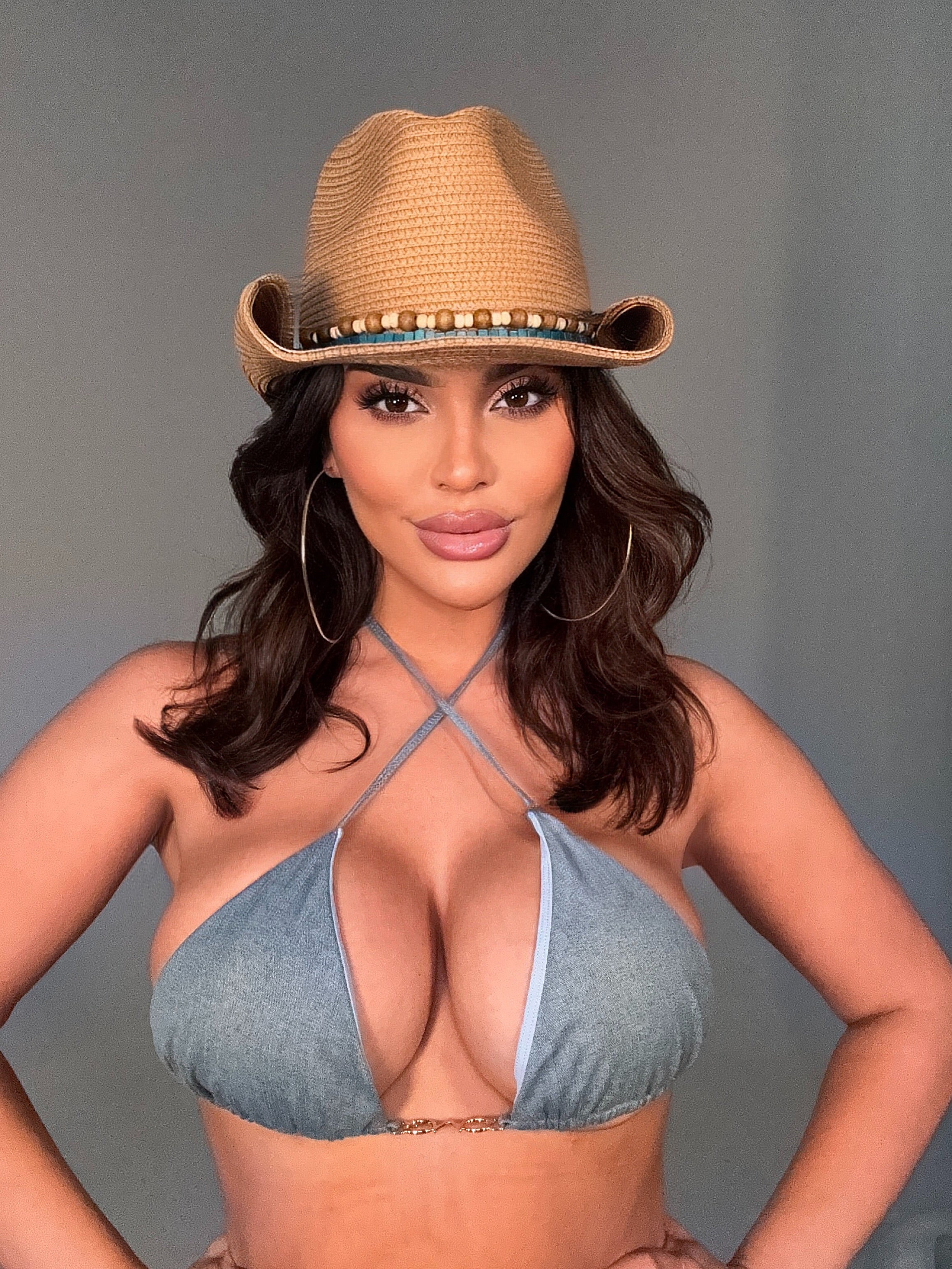Woman wearing a denim bikini and a cowgirl hat 